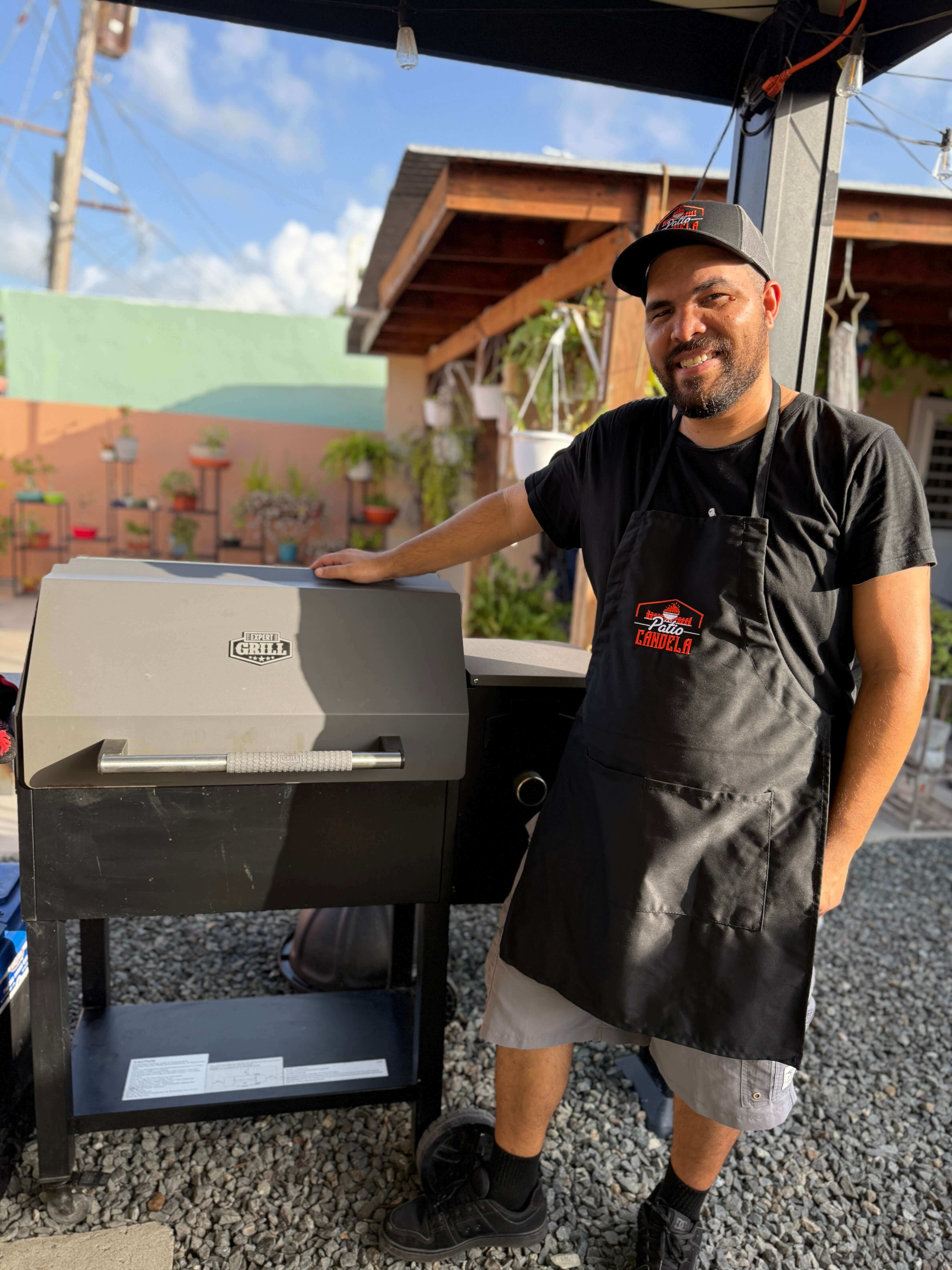Photo of Pitmaster Edwin with a pellet grill on his side.